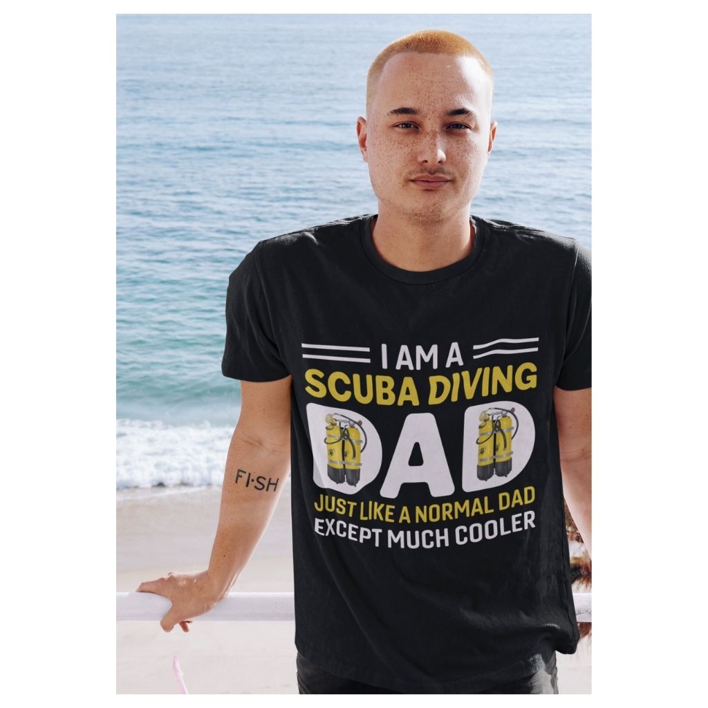 I am a scuba diving dad. Just like a normal dad except much cooler black tshirt worn by young guy with fish tattoo by the sea