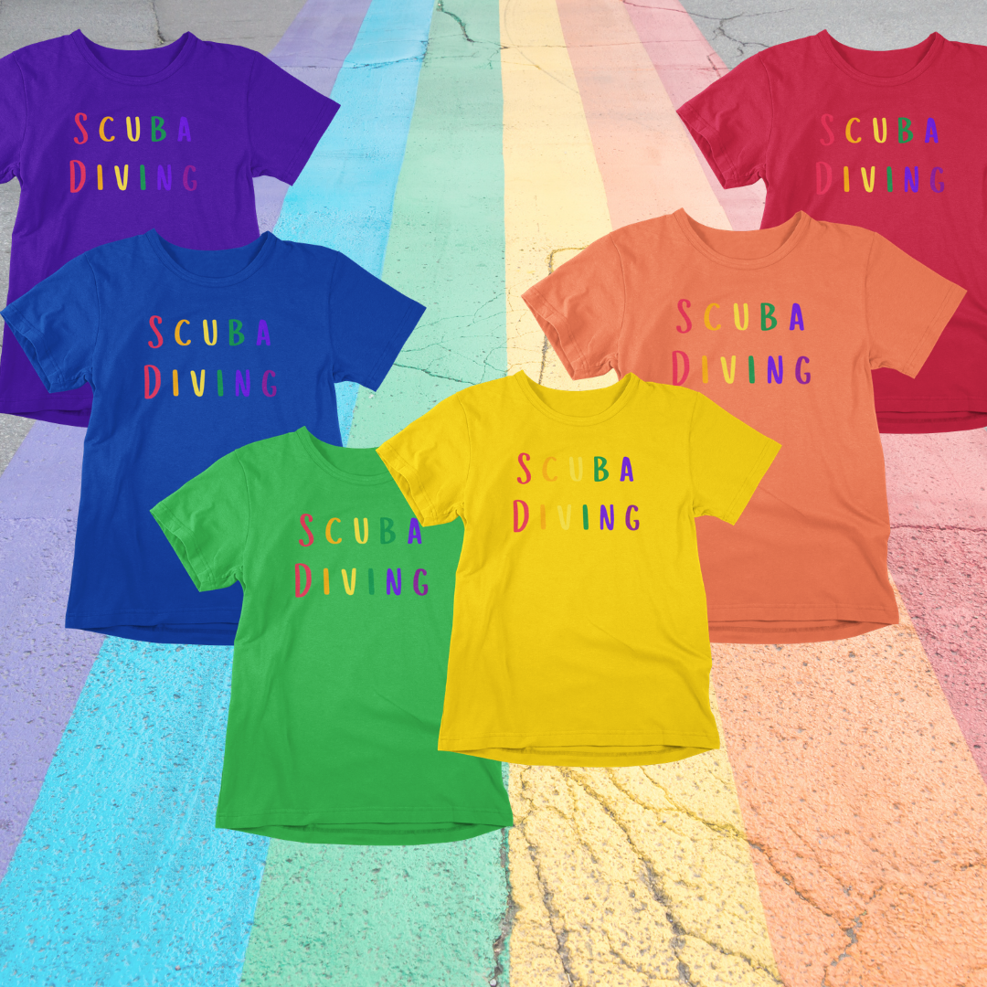 Purple blue green yellow orange and red scuba diving Pride LGBTQ+ T-shirts sitting on road colored with the rainbow flag