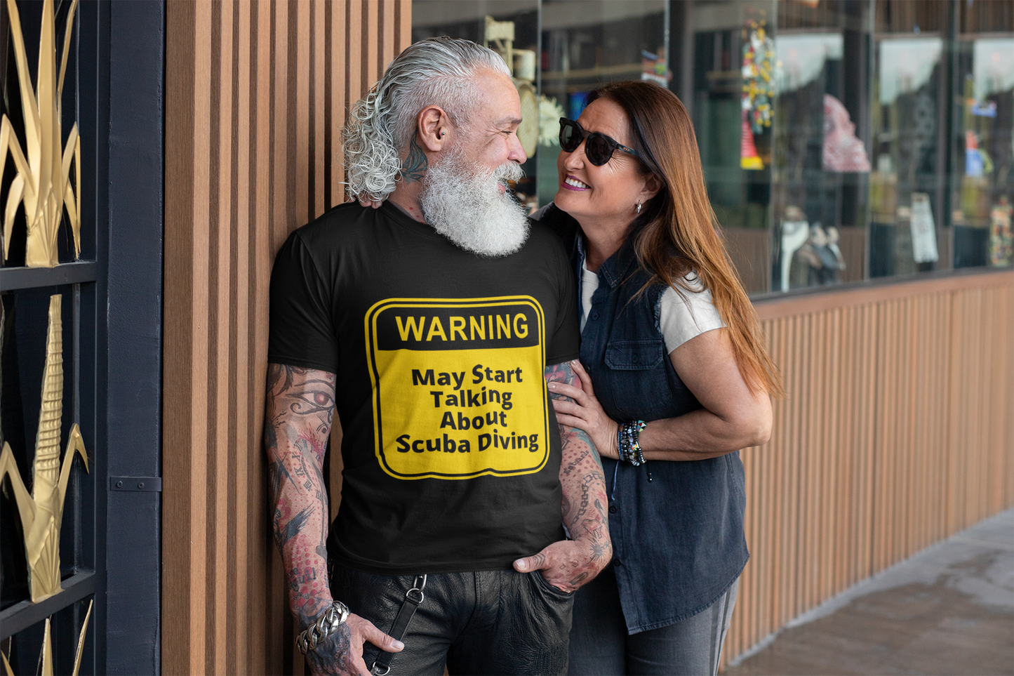 Warning: may start talking about scuba diving black t-shirt worn by a gentleman with tattoos and beard talking to a woman outside a cafe