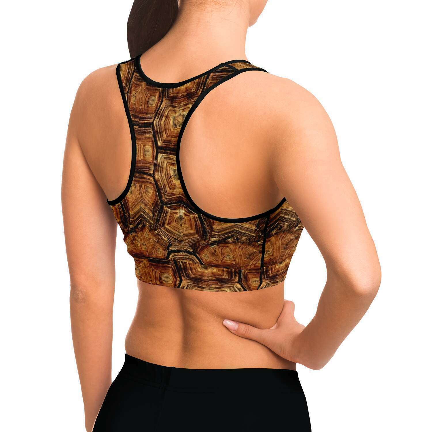Side view of model wearing turtle racer-back crop top / sports bra so can see under the arm stitching in black