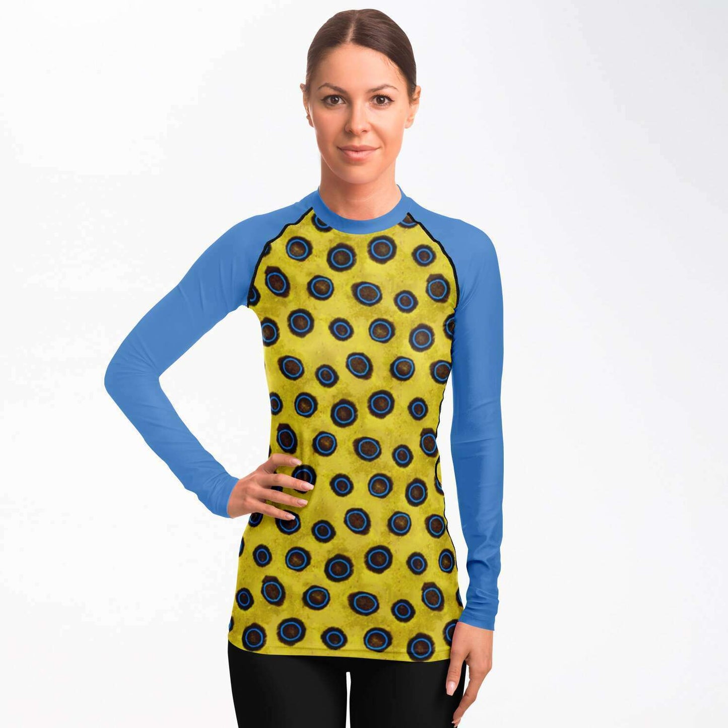 Front view of woman with hand on her hip wearing blue-ringed octopus rash guard
